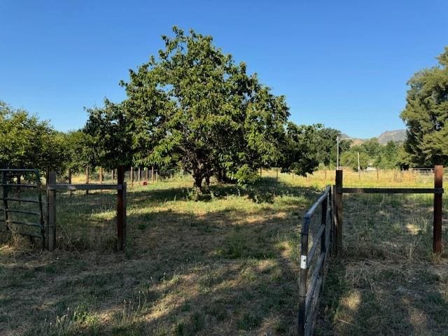 view of yard with a rural view and fence
