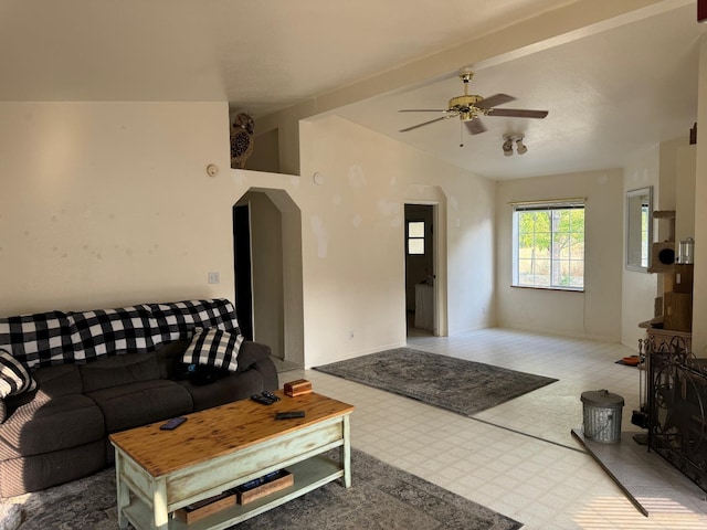 living room featuring ceiling fan and lofted ceiling with beams