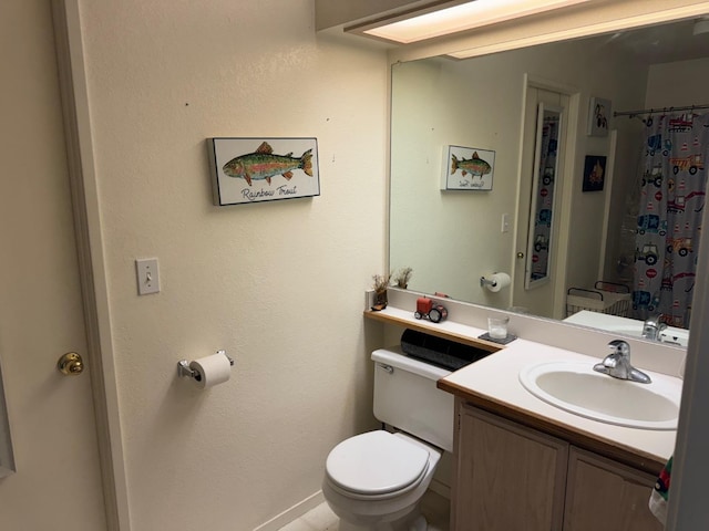 full bath featuring baseboards, vanity, and toilet