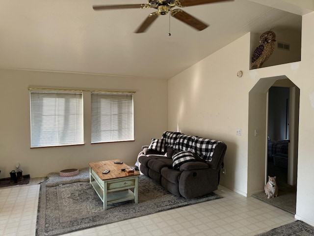 living room with tile patterned floors, arched walkways, vaulted ceiling, visible vents, and a ceiling fan