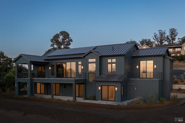 back house at dusk with a balcony