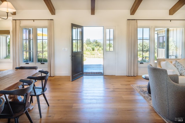 entryway with a wealth of natural light, light hardwood / wood-style floors, and beam ceiling