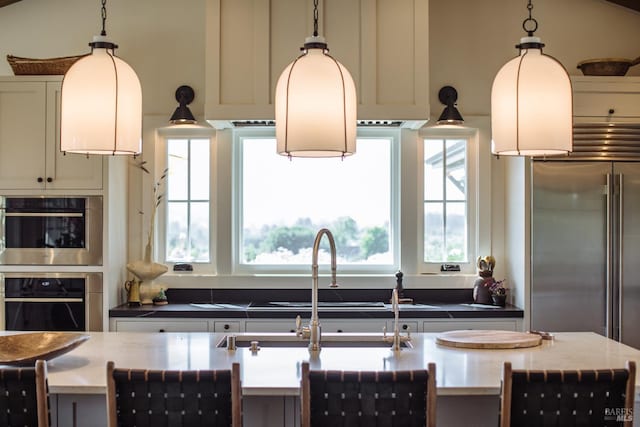 kitchen featuring stainless steel appliances and decorative light fixtures