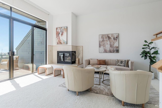 living room with a tile fireplace and carpet