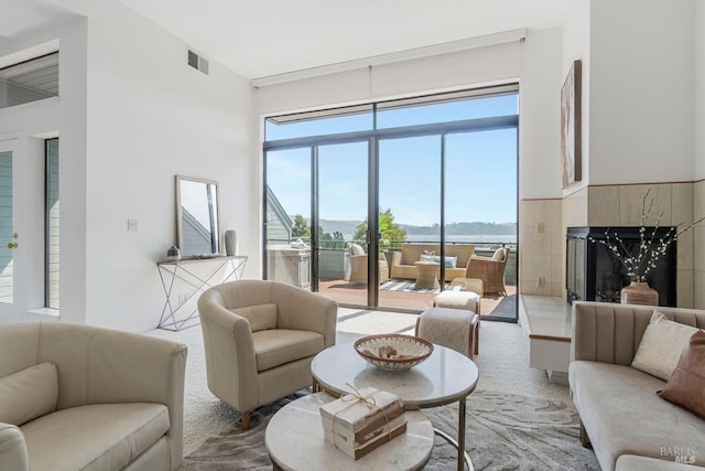 carpeted living room with a tile fireplace