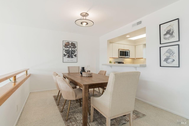 dining room featuring light carpet