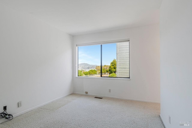 carpeted spare room featuring a mountain view