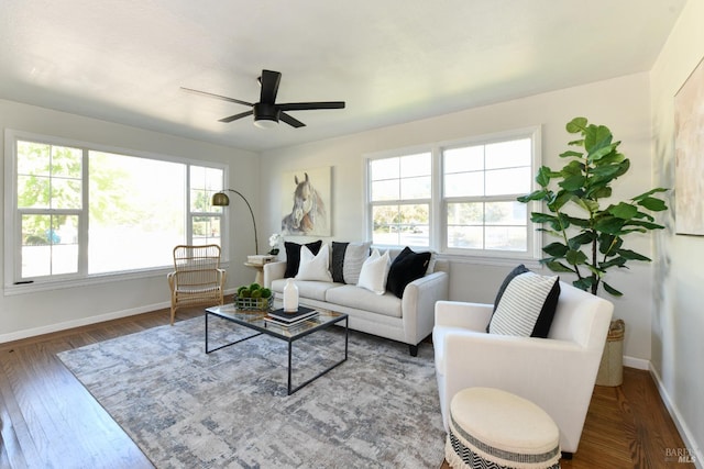 living room featuring dark wood-type flooring, ceiling fan, and plenty of natural light