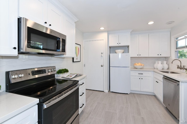 kitchen with stainless steel appliances, sink, and white cabinets