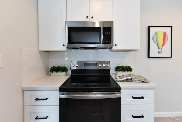 kitchen featuring black range with electric stovetop, backsplash, and white cabinets