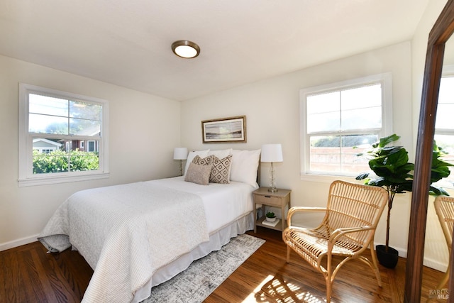 bedroom with dark hardwood / wood-style flooring and multiple windows