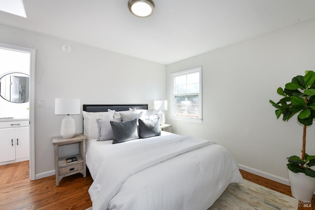 bedroom featuring a skylight and hardwood / wood-style floors