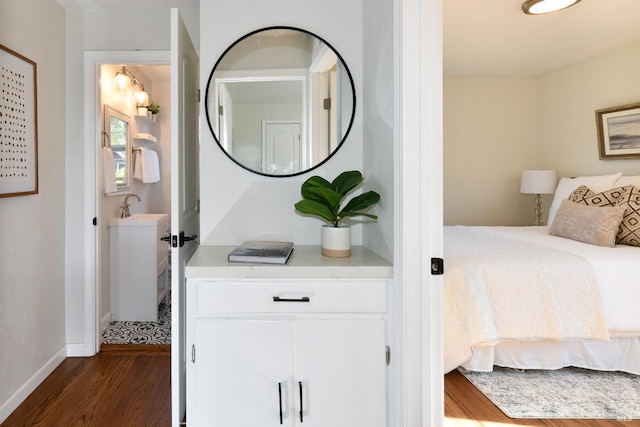 bedroom with dark hardwood / wood-style floors and sink