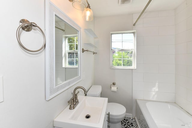 full bathroom with vanity, toilet, tiled shower / bath combo, and a wealth of natural light