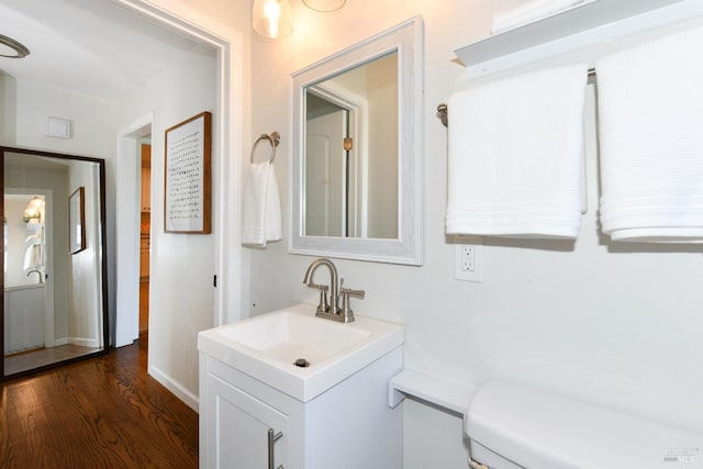 bathroom with hardwood / wood-style flooring, vanity, and toilet