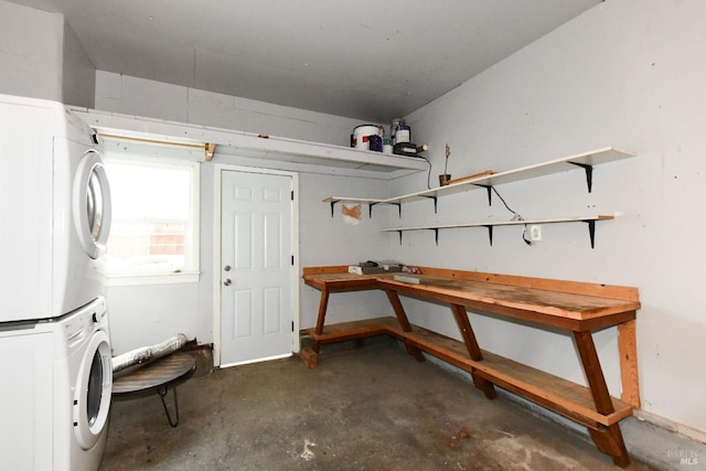 basement with stacked washer and clothes dryer and a workshop area