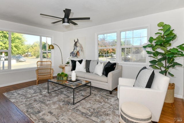 living room with dark wood-type flooring and ceiling fan