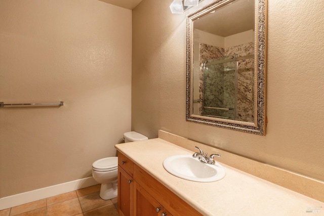 bathroom featuring tile patterned floors, toilet, vanity, and a shower with shower door