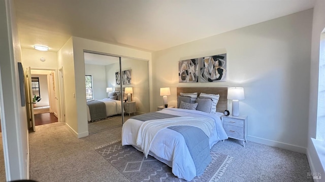 carpeted bedroom featuring a closet and baseboards