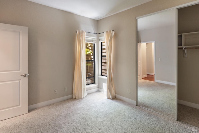 unfurnished bedroom with light carpet and a closet