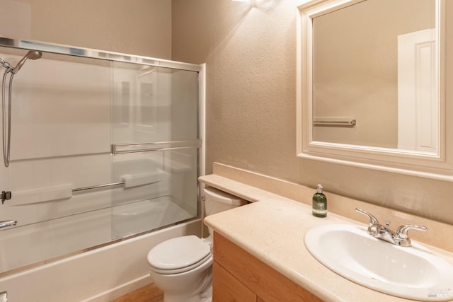 full bathroom with toilet, vanity, and shower / bath combination with glass door