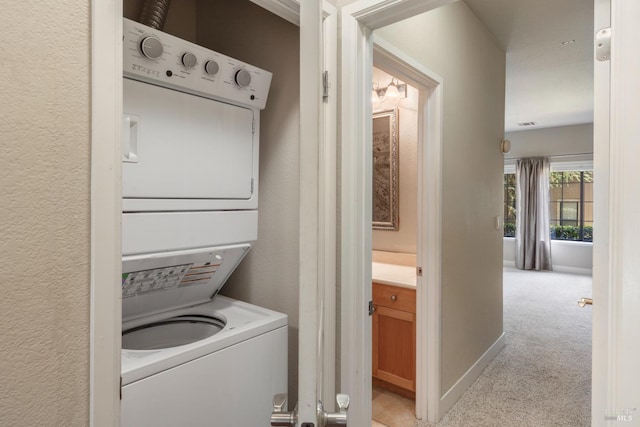 clothes washing area with light carpet and stacked washer and clothes dryer