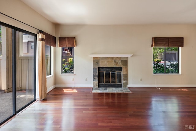 unfurnished living room with a tile fireplace and wood-type flooring