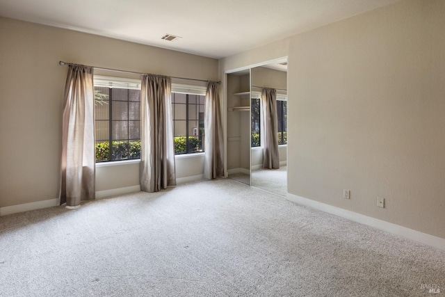 unfurnished bedroom with light carpet and a closet