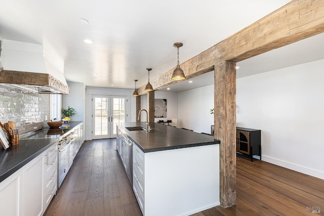 kitchen with sink, white cabinetry, a kitchen island with sink, decorative light fixtures, and french doors