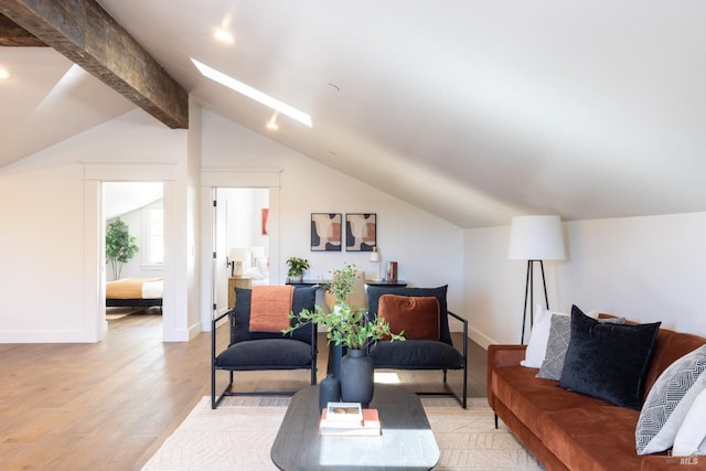 living room with vaulted ceiling with skylight and light wood-type flooring