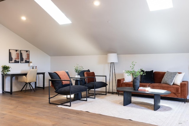 living area featuring lofted ceiling and light hardwood / wood-style floors