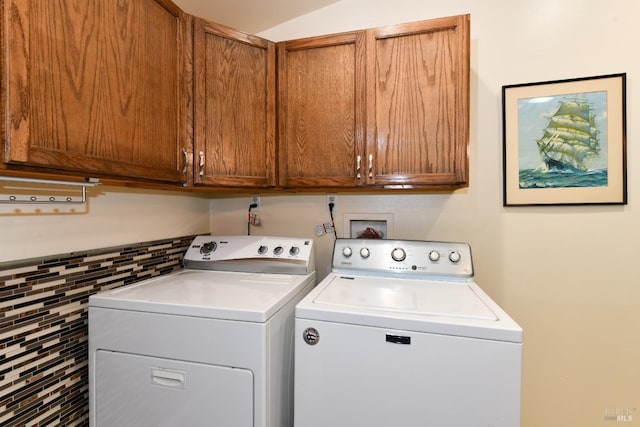 washroom featuring washing machine and clothes dryer and cabinets