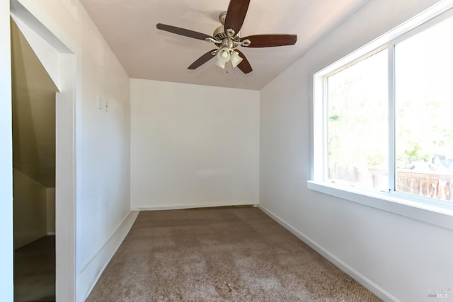 carpeted spare room featuring ceiling fan