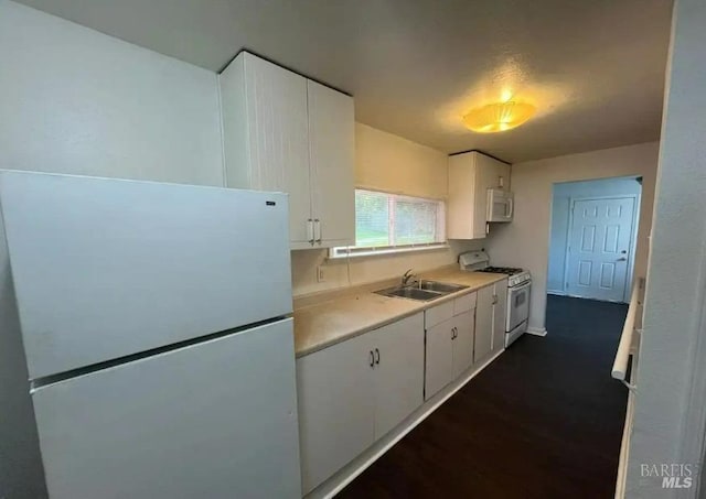 kitchen featuring dark wood-type flooring, sink, white cabinetry, and white appliances