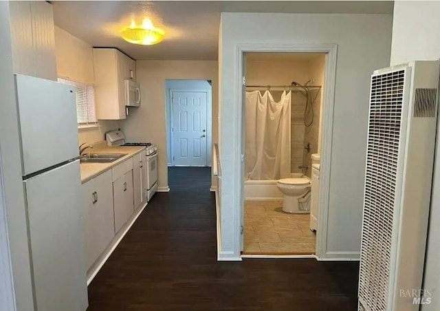 kitchen featuring dark hardwood / wood-style floors, sink, white fridge, white cabinetry, and range with gas stovetop