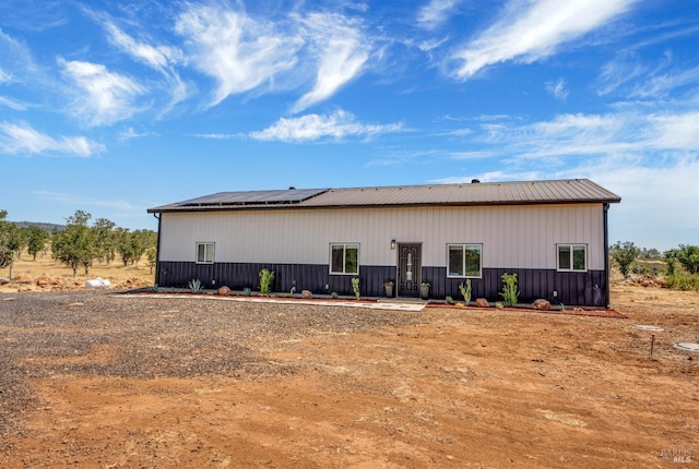 rear view of property featuring solar panels