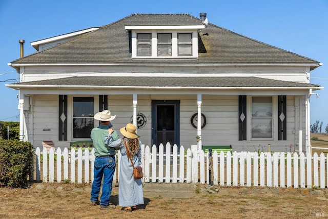 bungalow-style home with a porch and a fenced front yard