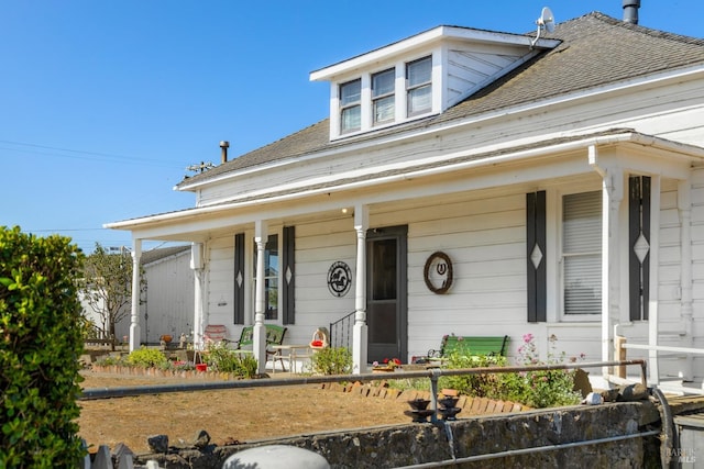 view of front of property with covered porch and roof with shingles