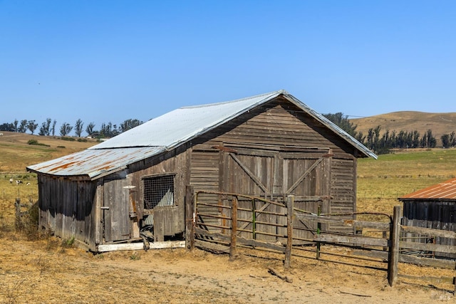 view of barn featuring fence