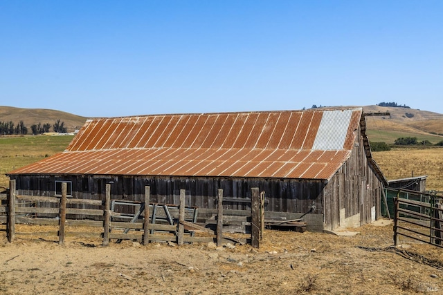 view of horse barn with a mountain view and a rural view