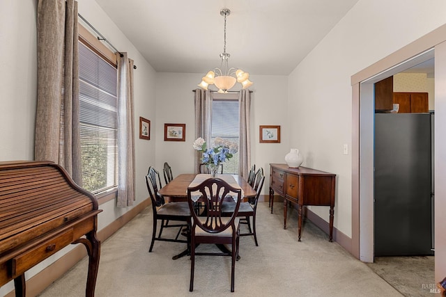 dining area with a wealth of natural light, light carpet, and an inviting chandelier