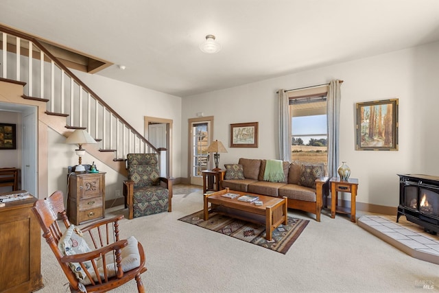 carpeted living area with baseboards, a wood stove, and stairs