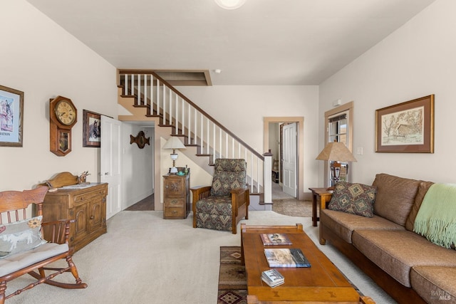 living area featuring light carpet and stairs