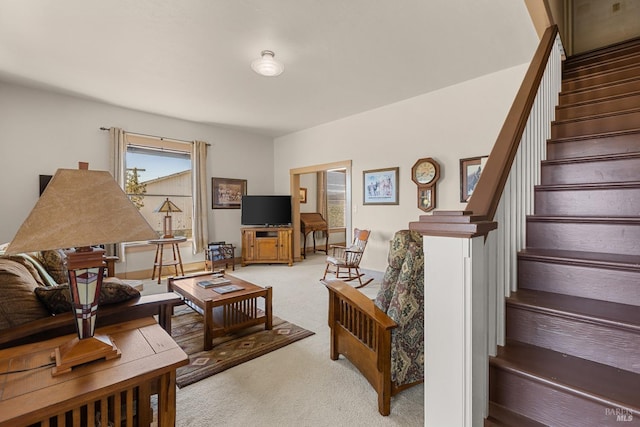 living area featuring stairway and light colored carpet