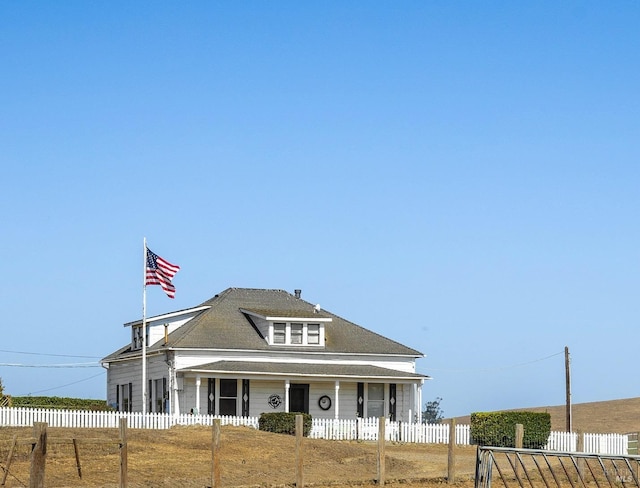farmhouse-style home with a fenced front yard