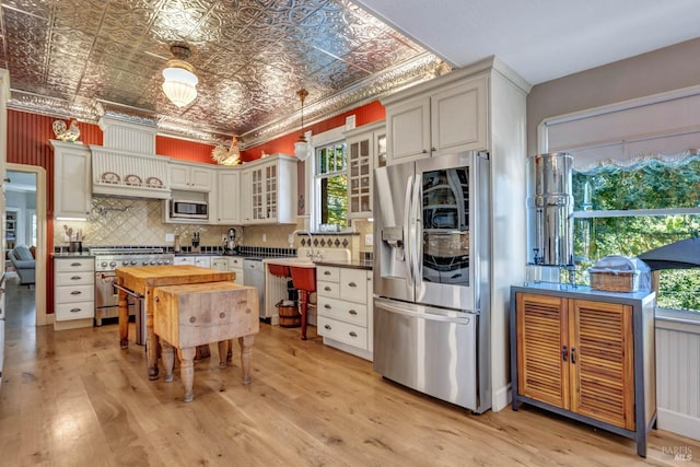 kitchen featuring light hardwood / wood-style floors, stainless steel appliances, and backsplash