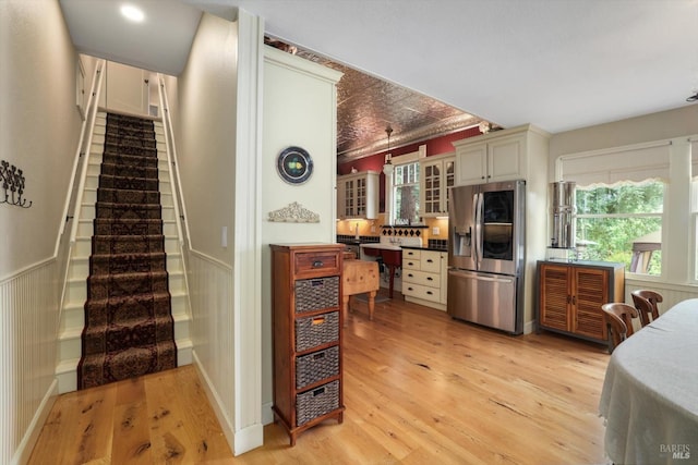 kitchen with a healthy amount of sunlight, light wood-type flooring, and stainless steel refrigerator with ice dispenser