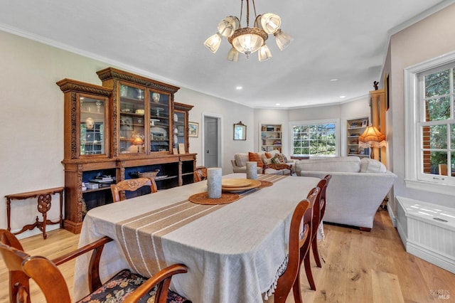 dining room with ornamental molding and light wood-type flooring