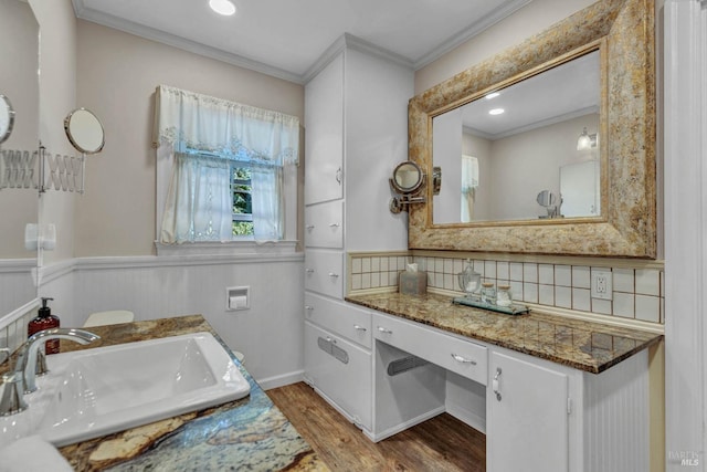 bathroom featuring ornamental molding, vanity, wood-type flooring, and backsplash