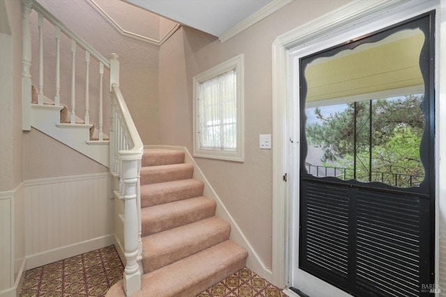 staircase featuring tile patterned floors and ornamental molding